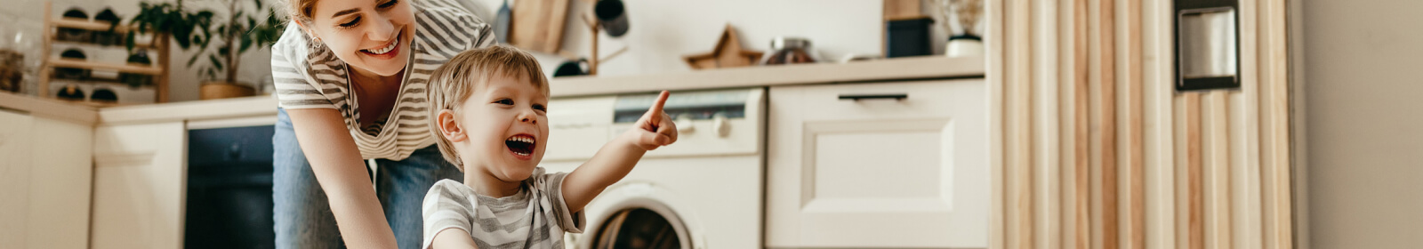 A mom and toddler playing in a laundry room